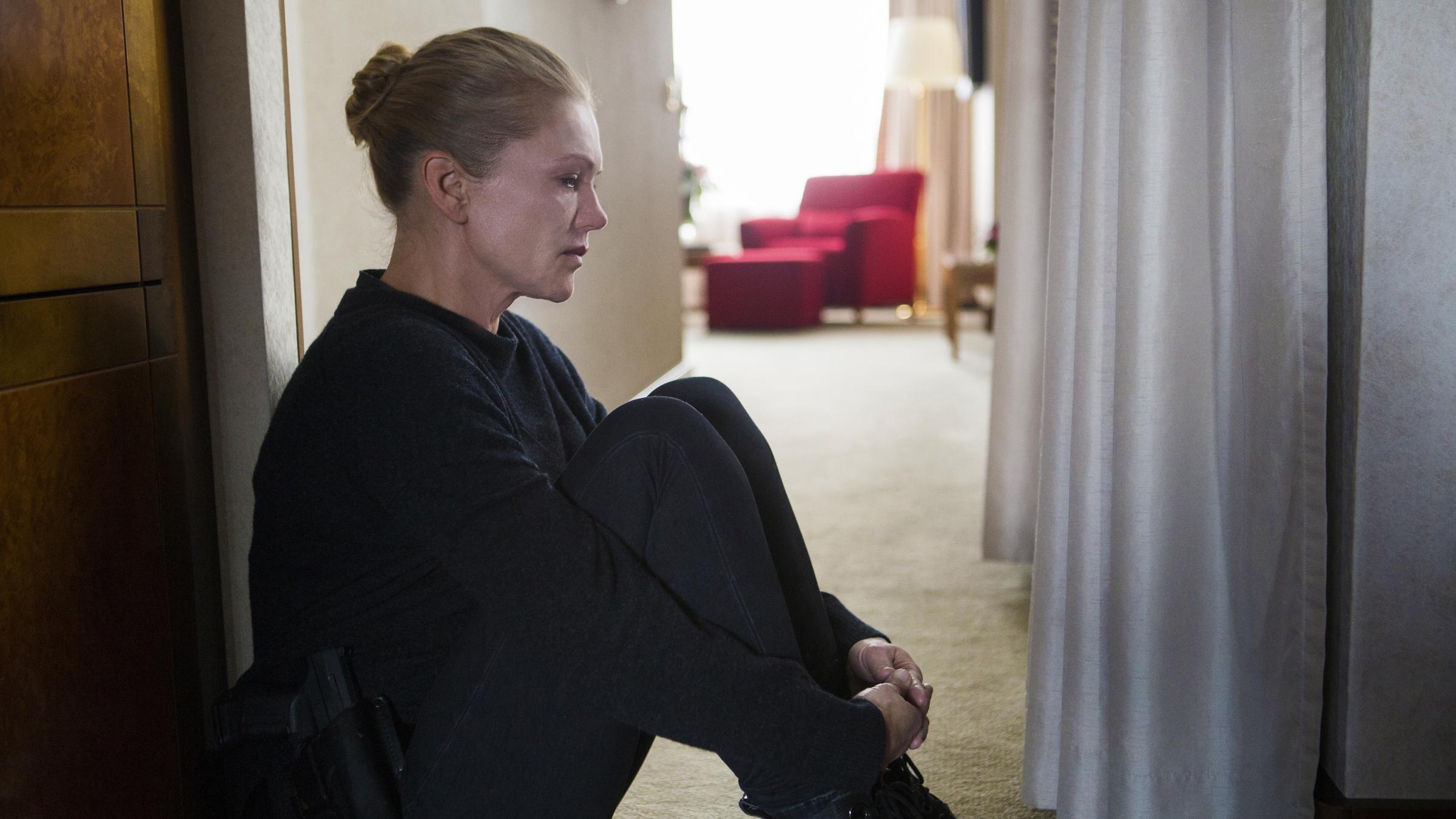 "Helen Dorn - Prager Botschaft": Helen Dorn (Anna Loos) sitzt im Flur auf dem Boden und schaut vor sich auf den Boden.