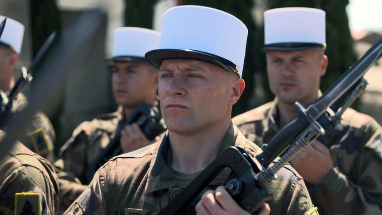 "Fremdenlegion - Die härteste Elitetruppe der Welt": Ronny Bethge und weitere Legionäre in Uniform und mit Gewehr.