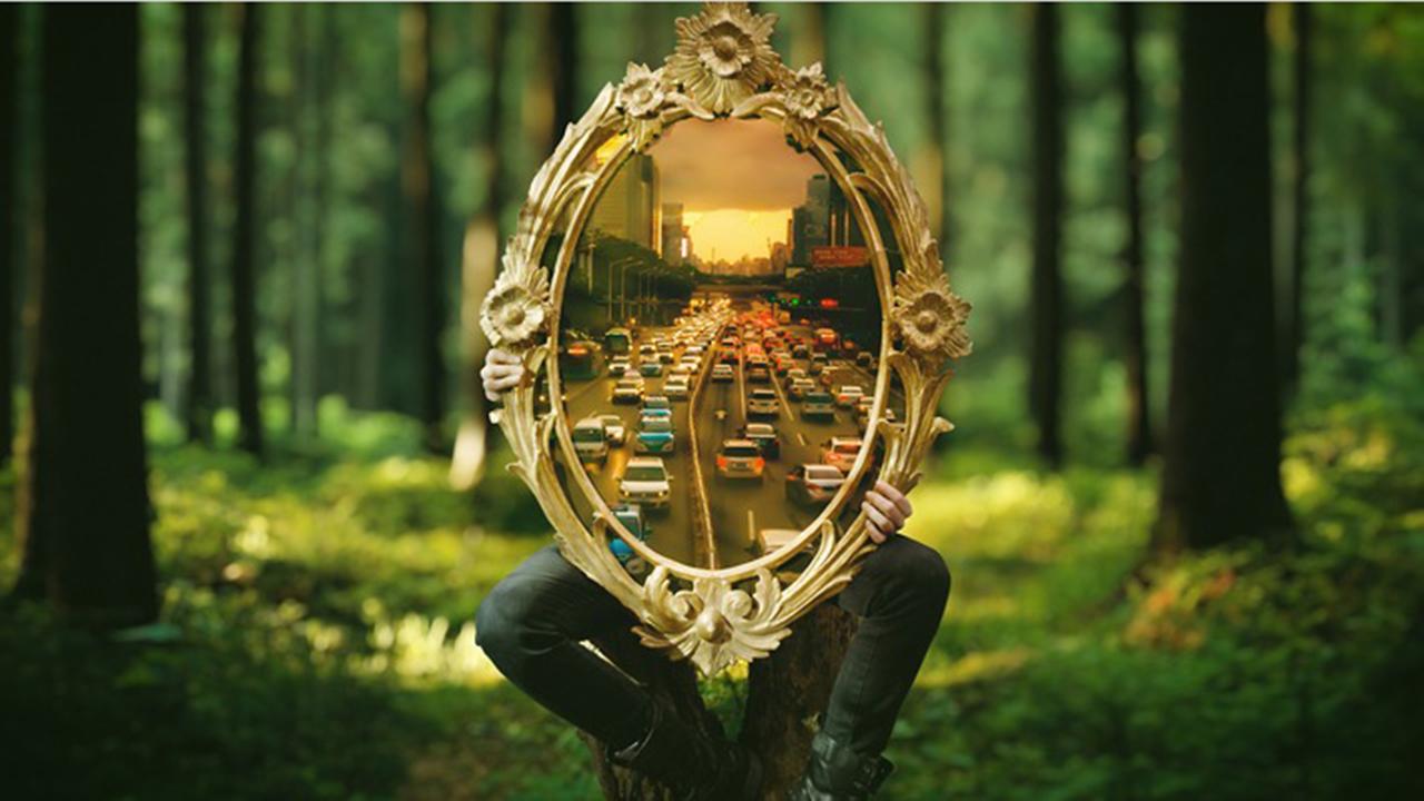 3sat Kulturdokumentationen: Ein Mann sitzt mitten im Wald auf einem Baumstumpf und ist bis zu den Beinen von einem ovalen Spiegel verdeckt, den er vor sich hält. Darim spieglen sich Autokolonnen auf einer mehrspurigen Straße.