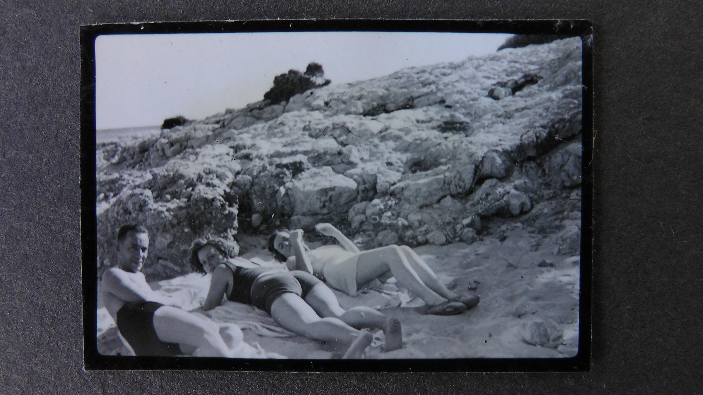 "ZDF-History: Mallorca - Eine deutsche Liebe": Schwarz-Weiß-Foto: Zwei Frauen und ein Mann liegen am Strand und sonnen sich. Alle schauen in die Kamera.
