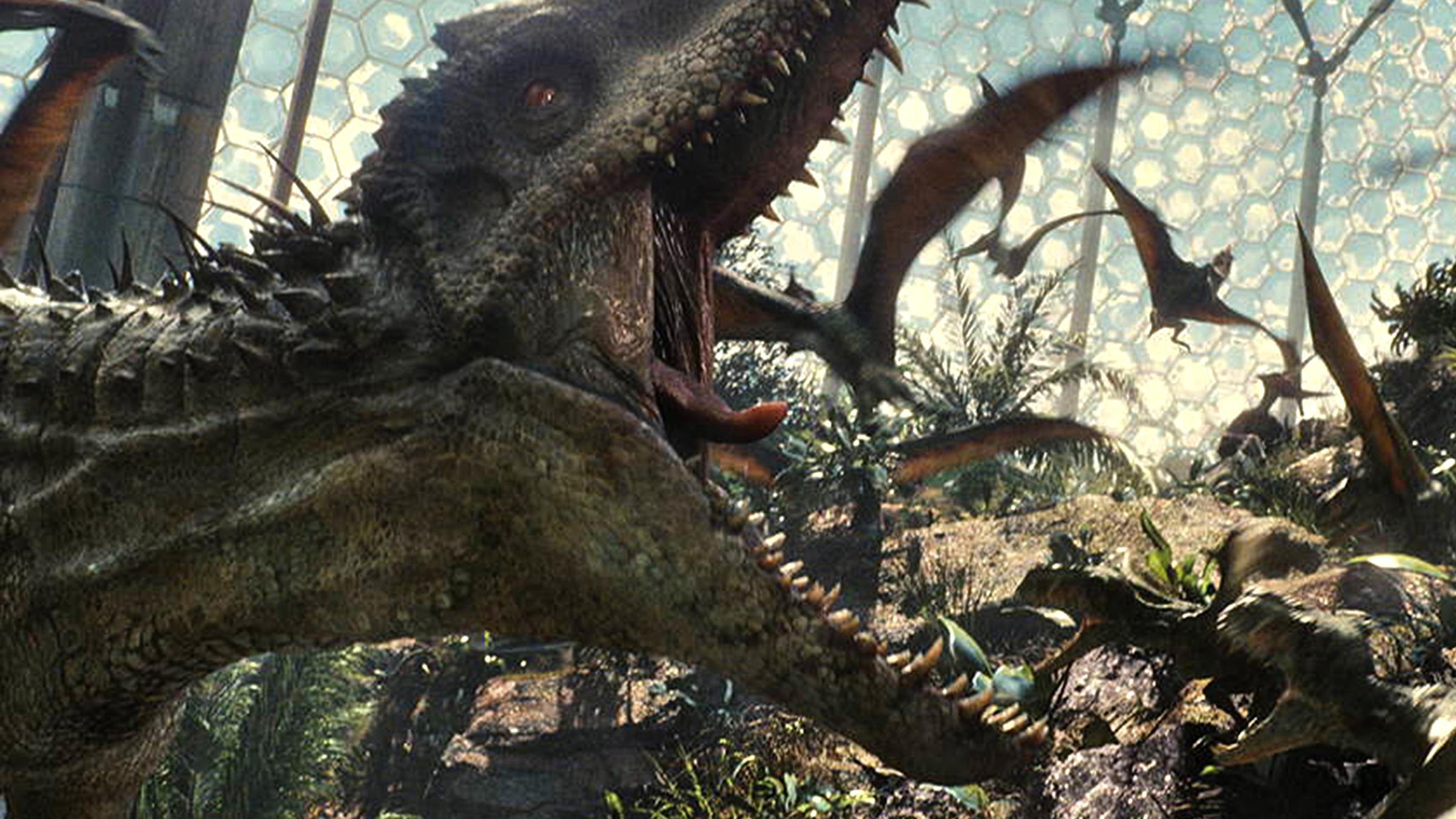 "Jurassic World": Ein Saurier, der "Indominus Rex" reißt sein Maul auf. Umgeben ist er von kleineren Flugsauriern.