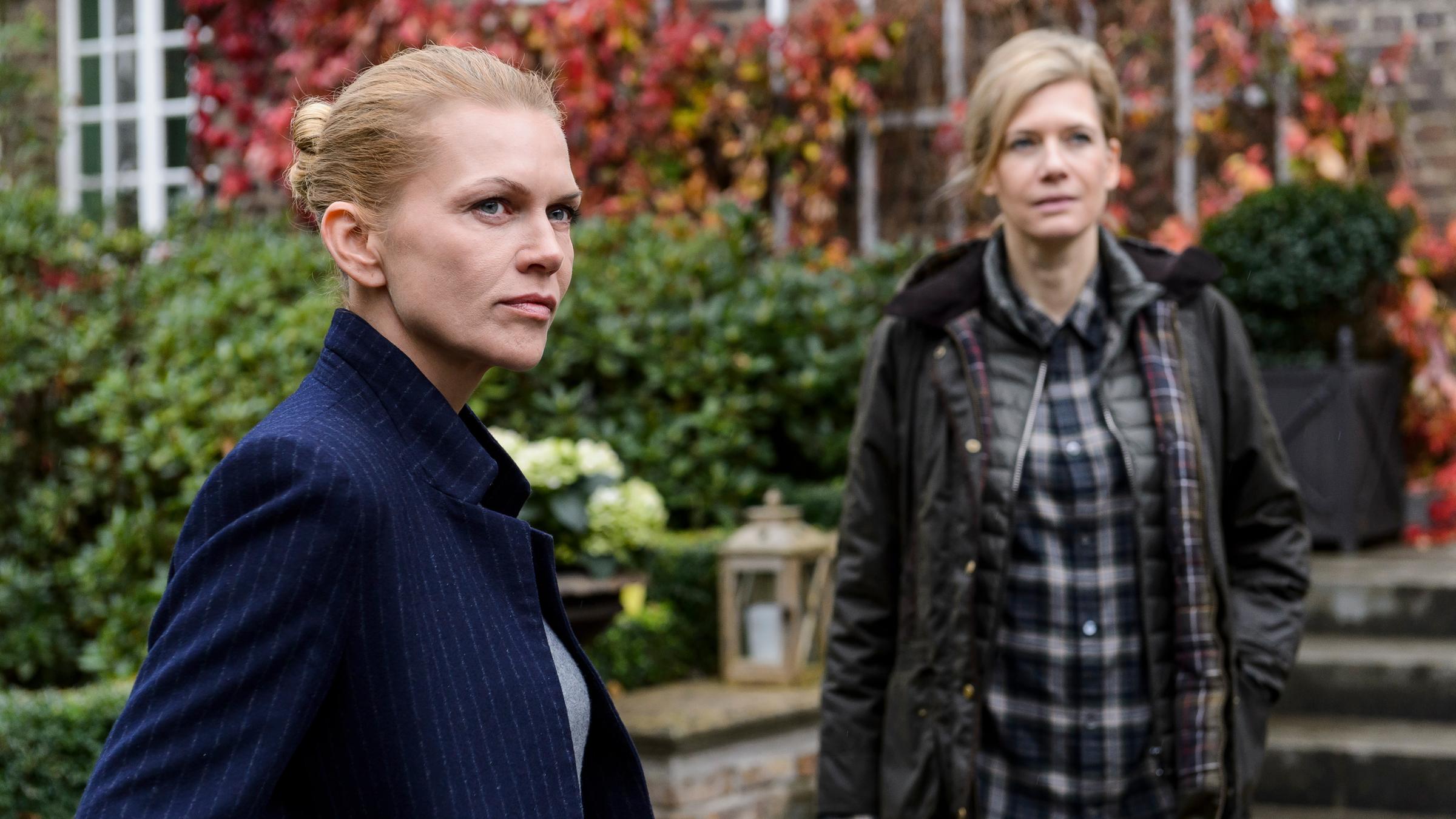 "Helen Dorn - Schatten der Vergangenheit": In Nahaufnahme Helen Dorn (Anna Loos) und Britta Lorenz (Ina Weisse). Im Hintergrund das Anwesen der Familie Lorenz.