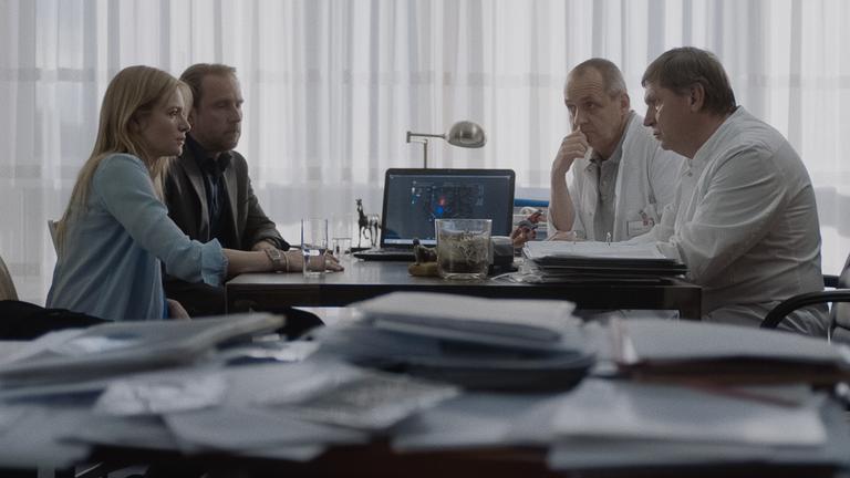  "24 WOCHEN": Astrid (Julia Jentsch) und Markus (Bjarne Mädel) sitzen in einem Praxiszimmer zwei Ärzten (Darsteller unbekannt) gegenüber.