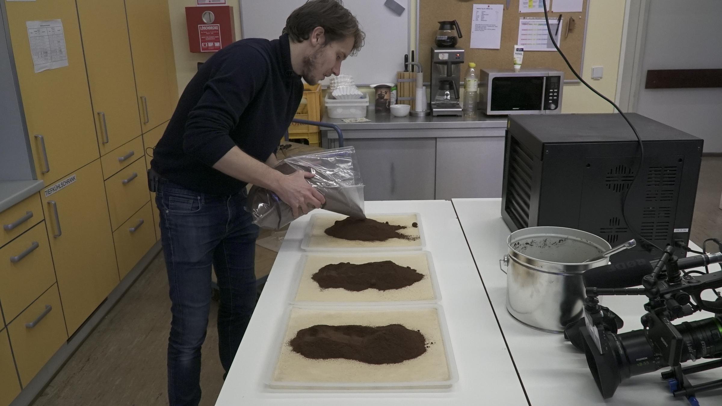 "planet e.: Die Rohstoff-Pioniere - Wie Deutschlands Tüftler neue Ökoprodukte erfinden": Rohstoff-Pionier Julian Lechner breitet Brühabfälle vom Kaffeesatz auf einem Tisch aus.