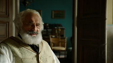 "Karl Marx - der deutsche Prophet": Spielszene: Karl Marx (Mario Adorf) sitzt in seinem Wohnzimmer und schaut nachdenklich nach vorne.