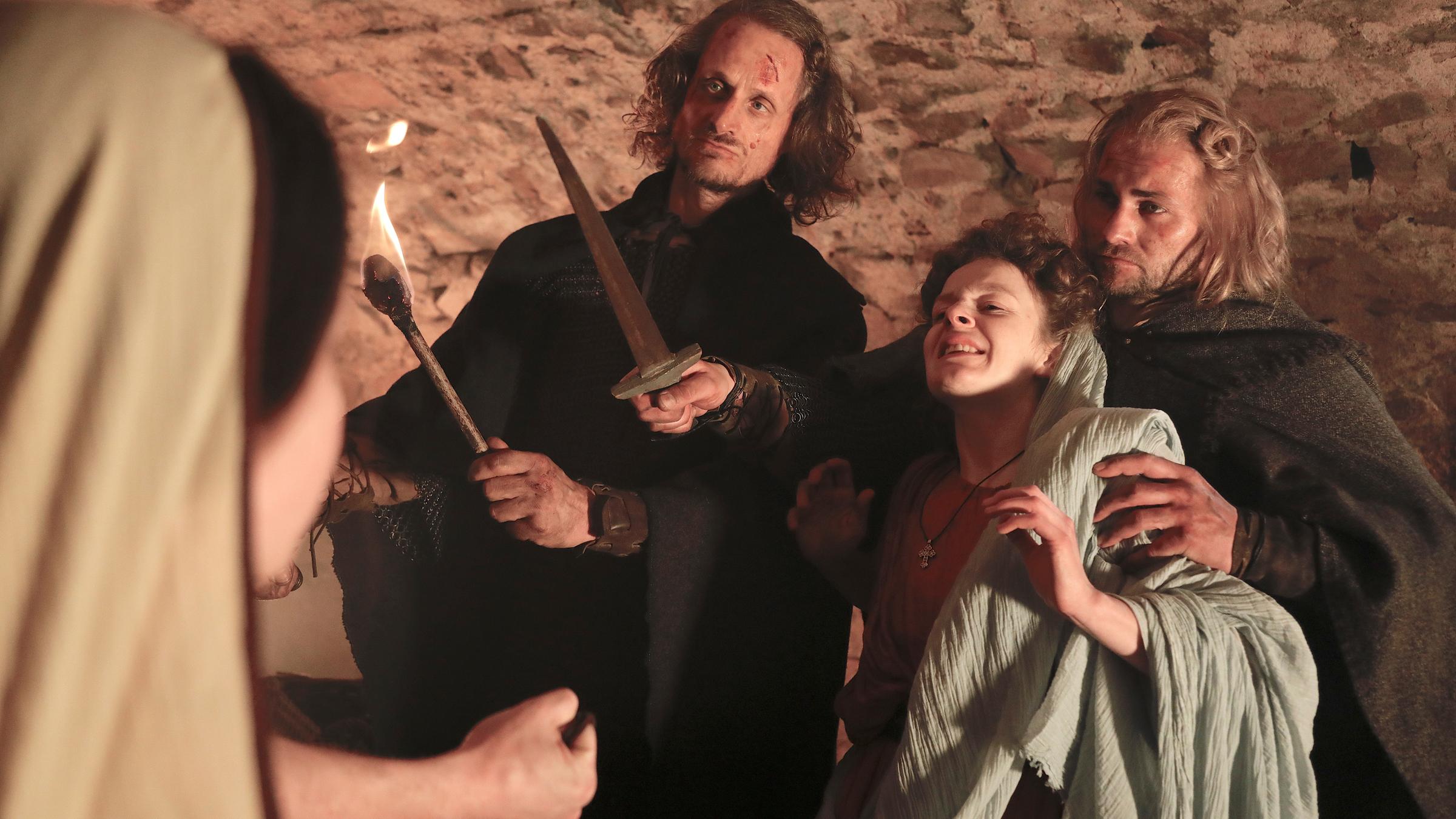 "Das Kreuz mit dem Frieden - Die Christen und der Krieg": Eine römische Familie versteckt sich in den Katakomben, sie werden von gotischen Soldaten mit Dolchen bedroht. Eine ängstliche Frau wird von einem der Soldaten festgehalten.