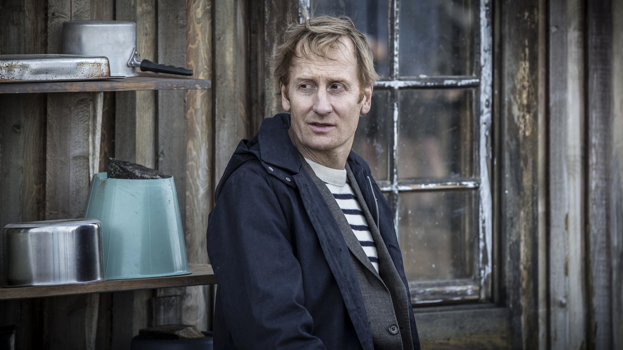 "Midnight Sun - Die Todesliste":  Anders Harnesk (Gustaf Hammarsten)  steht vor einer verwitterten Holzhütte.