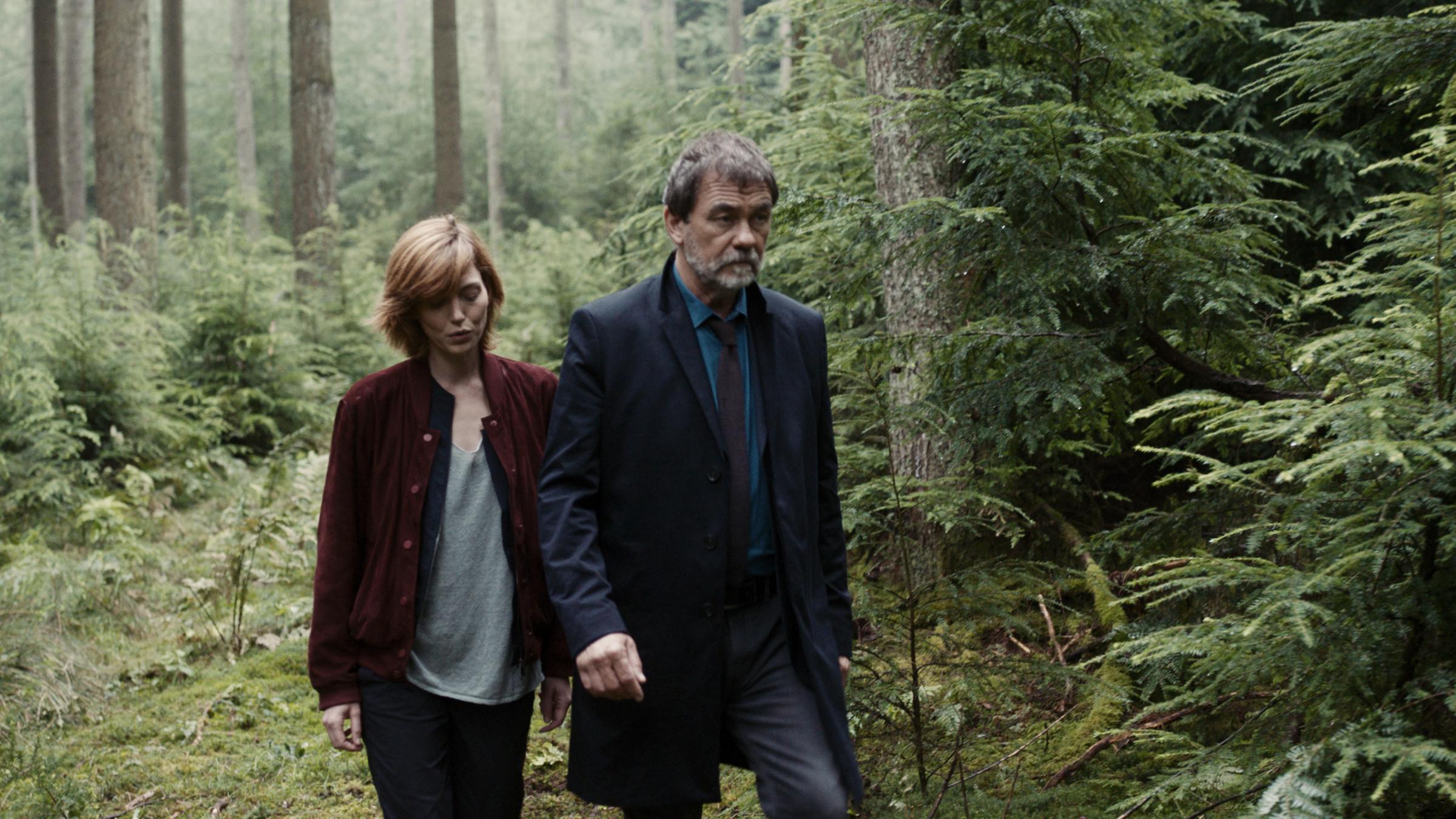 "Die letzte Jagd": Pierre Niémans (Olivier Marchal) und Camille Delauney (Erika Sainte) laufen durch einen Wald.