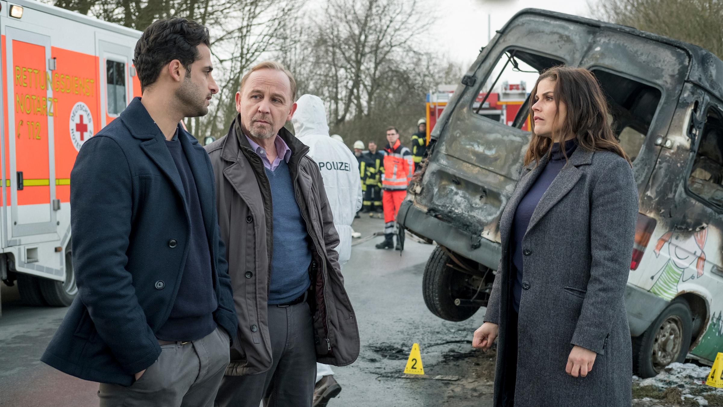 "Stralsund - Waffenbrüder": Karim Uthmann (Karim Günes, l.), Karl Hidde (Alexander Held, M.) und Nina Petersen (Katharina Wackernagel) stehen am Unfallort.