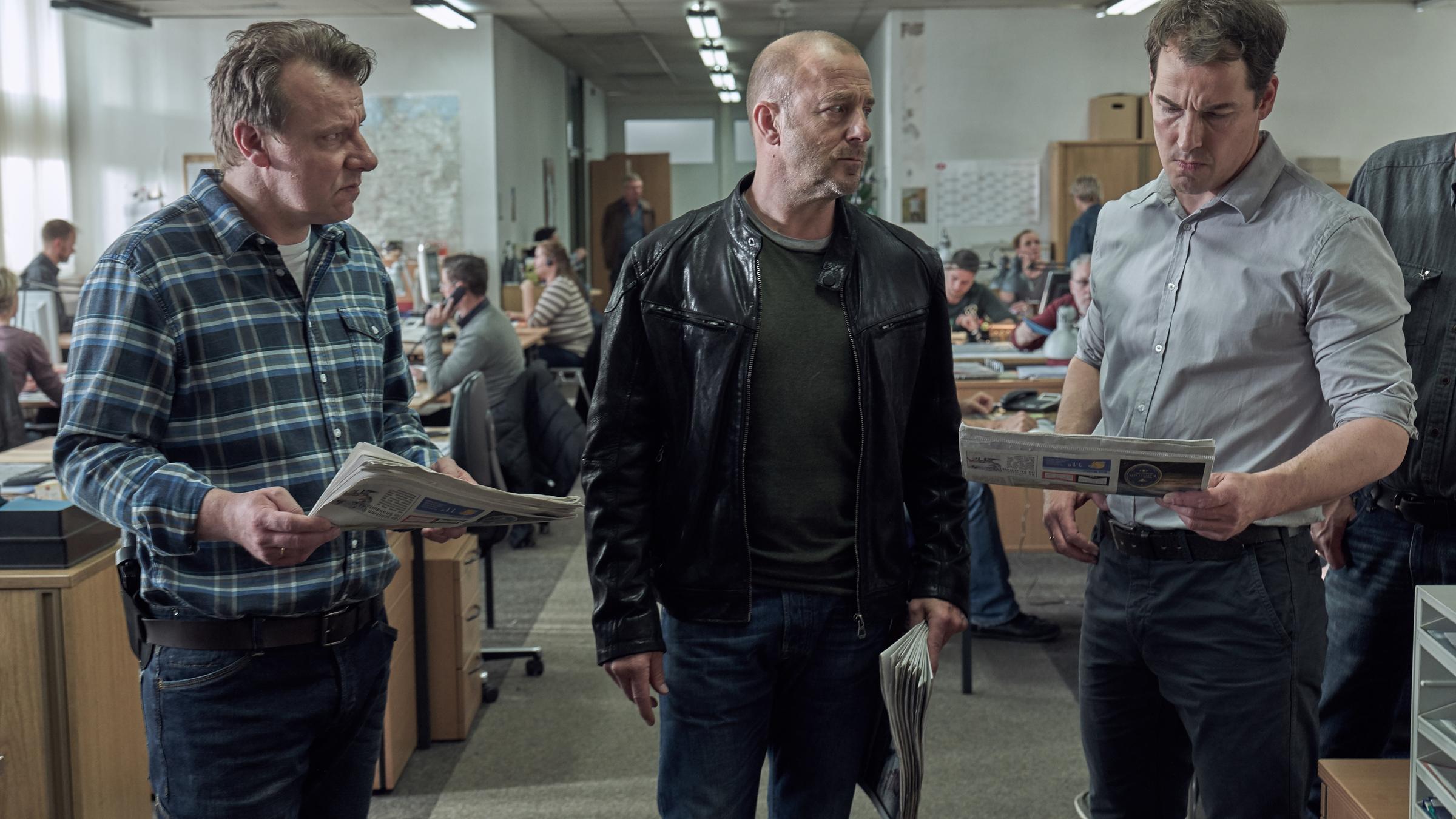 „Ein Kind wird gesucht“: Winfried Karls (Ronald Kukulies), Ingo Thiel (Heino Ferch) und Mario Eckartz (Felix Kramer) stehen mit Zeitungen in der Hand im Büro.