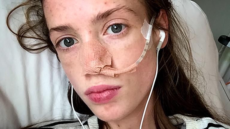 "Emma will leben" - Nahaufnahme : Gesicht eines extrem abgemagerten Mädchens. Eine Sonde (dünner Schlauch) führt in ihre Nase. Die Nase ist mit Pflaster verklebt, damit die Sonde besser hält.