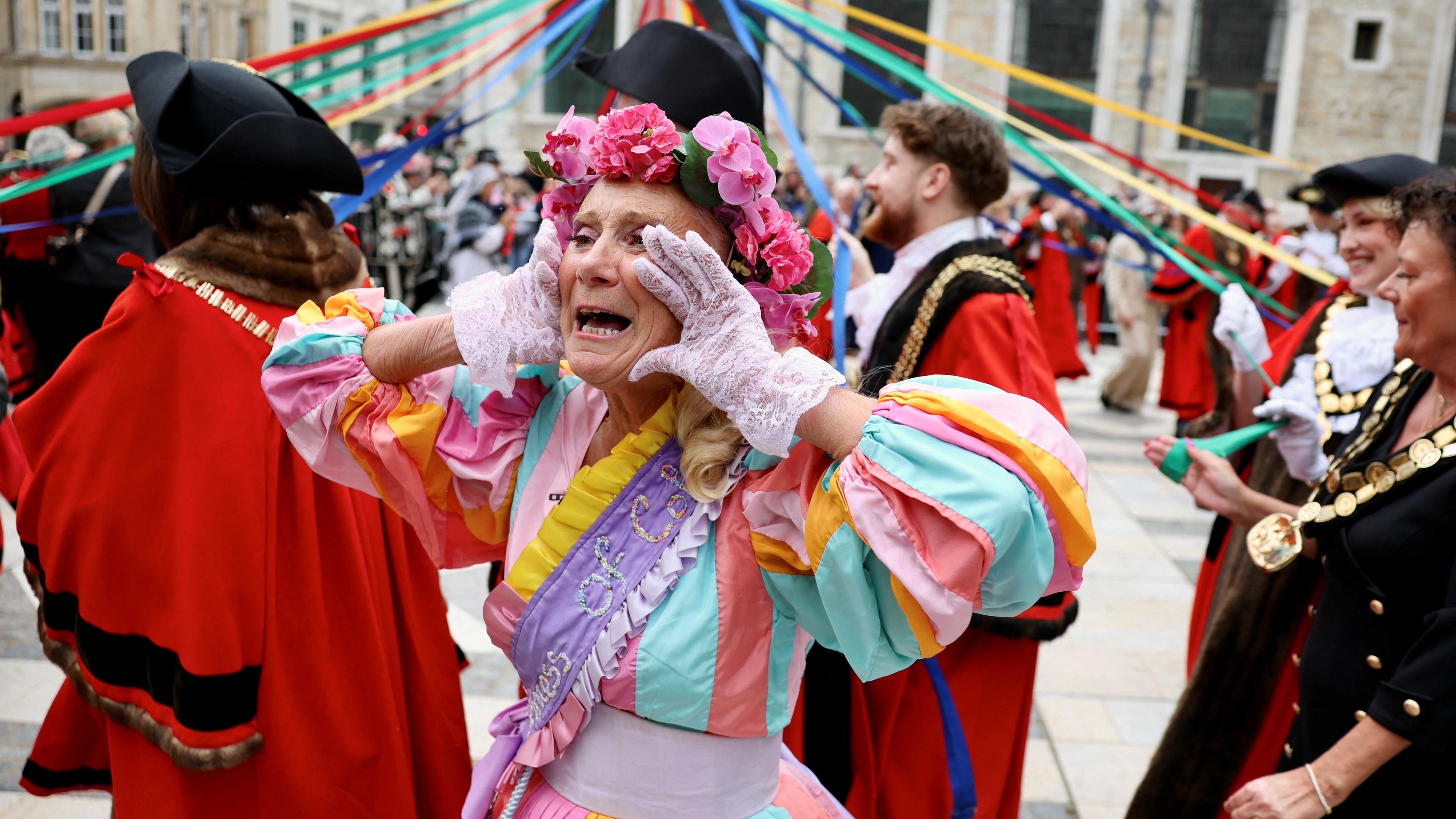 Frau im Kostüm ruft, im Hintergrund verkleidete Männer