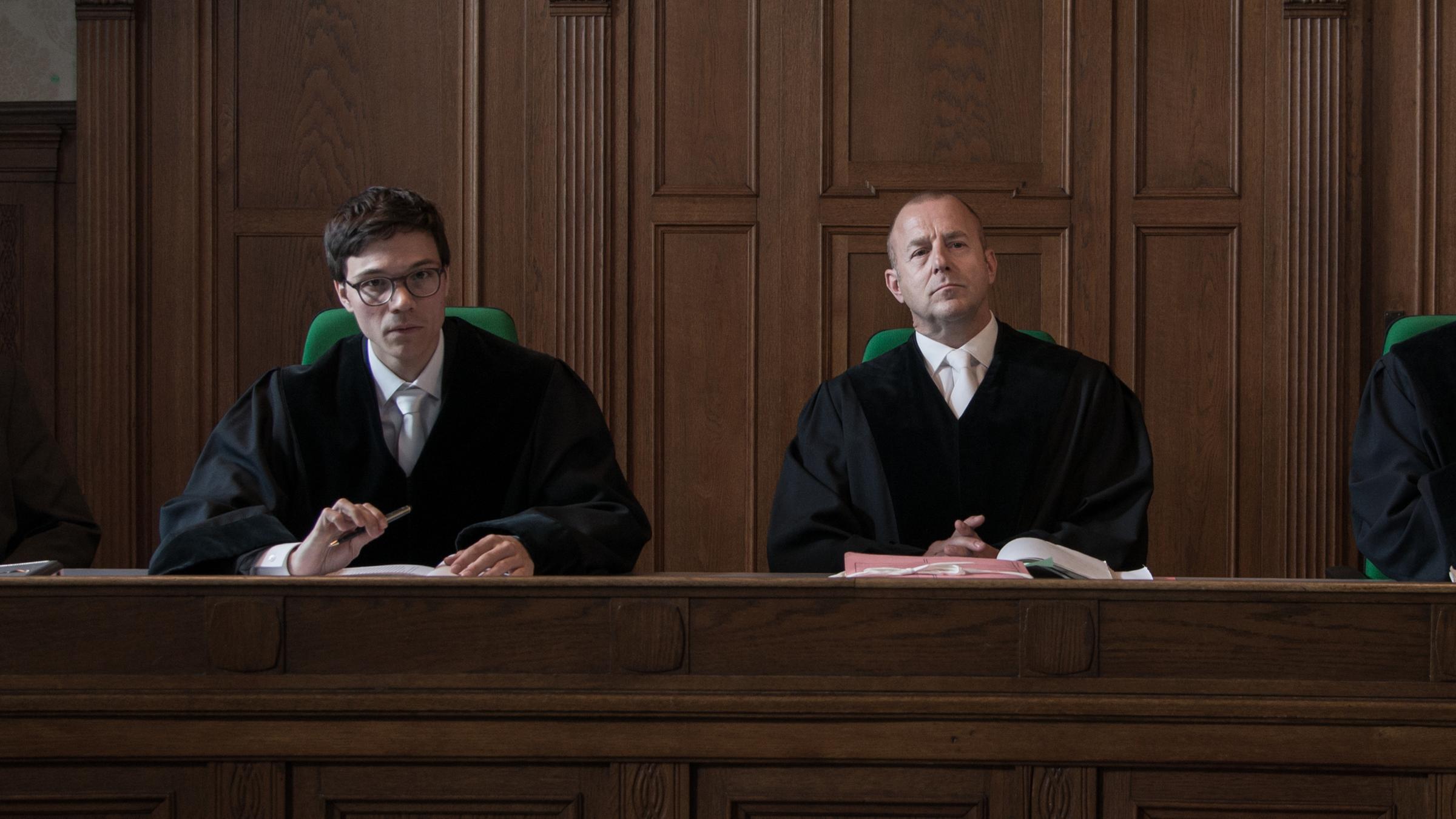"Der Richter": Im Gerichtssaal sitzen der Vorsitzende Richter Glahn (Heino Ferch) und Richter Wollenkamp (Sebastian Urzendowsky) nebeneinander. Beide schauen nach vorne.