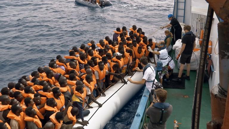 "Seenotretter im Shitstorm: Wenn Hilfe Hass erzeugt": Filmautor Carsten Behrendt filmt auf der "Iuventa" die Hilfsaktion von "Jugend Rettet". Gerade geht ein miit Flüchtlingen überfülltes Schlauchboot längsseits.
