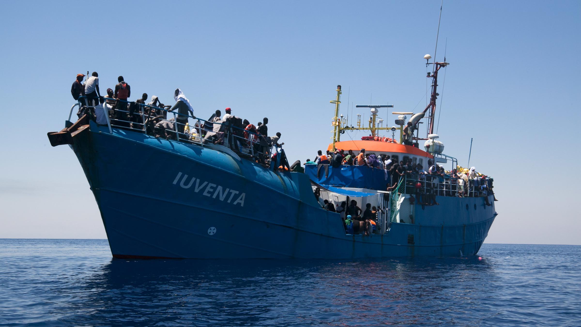 "I"Iuventa": Ein mit Menschen vollbesetztes Frachtschiff mit dem Namenszug „Iuventa“, von einem anderen Boot aus fotografiert, liegt im Mittelmeer.