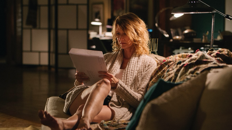 "The Tale": Jennifer (Laura Dern) sitzt in einem Sessel im Wohnzimmer und betrachtet verunsichert einen alten Papierumschlag in ihren Händen.