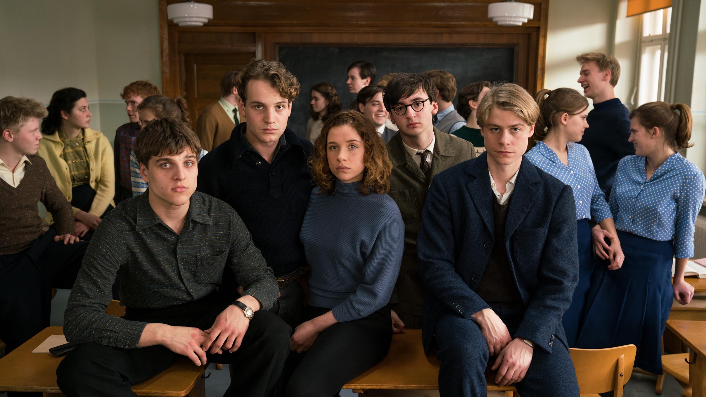 "Das schweigende Klassenzimmer": Eric (Jonas Dassler, l.), Theo (Leonard Scheicher, 2.v.l.), Lena (Lena Klenke), Paul (Isaiah Michalski, 2.v.r.) und Kurt (Tom Gramenz, r.) mit ihren Mitschülern im Klassenraum.