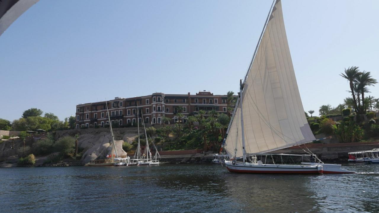 An den Ufern des Nil (ARTE):  Ein Segelboot auf dem Nil. Im Hintergrund eine Anlegestelle und das Assuan Old Cataract-Hotel