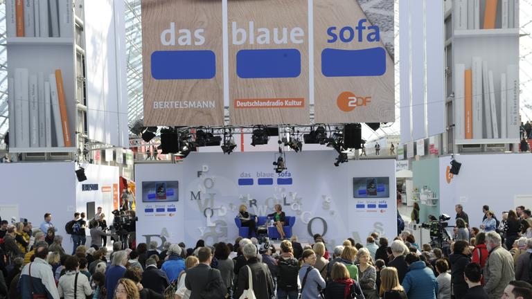 "das blaue sofa" auf der Leipziger Buchmesse: Luzia Braun mit Heike Melba-Fendel sitzen zum Gespräch nebeneinander auf dem blauen Sofa.