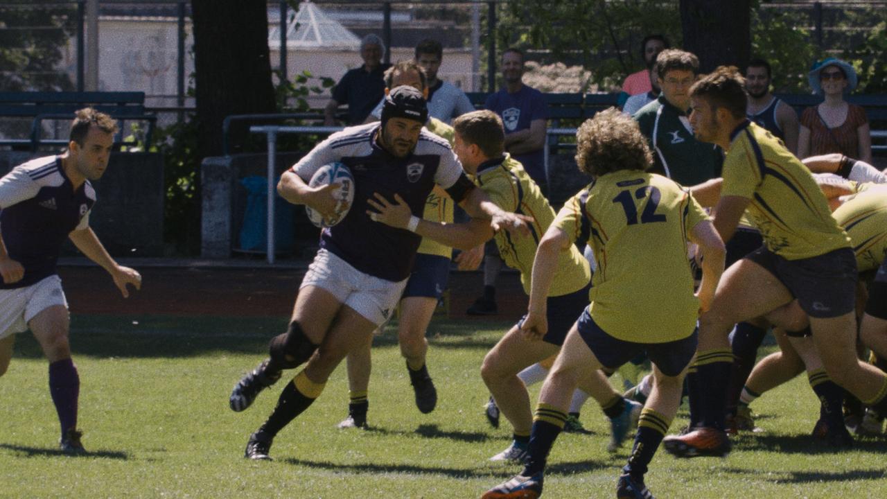 „Tackling Life“: Eine Gruppe Männer in weiß-blauen und gelb-schwarzen Trikots