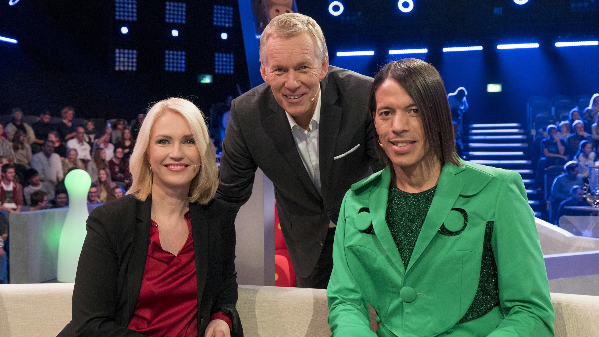 "Das Spiel beginnt! - Die große Show von 3 bis 99": Manuela Schwesig, Johannes B. Kerner und Jorge González lächeln in die Kamera. Im Hintergrund ist das Publikum zu sehen.
