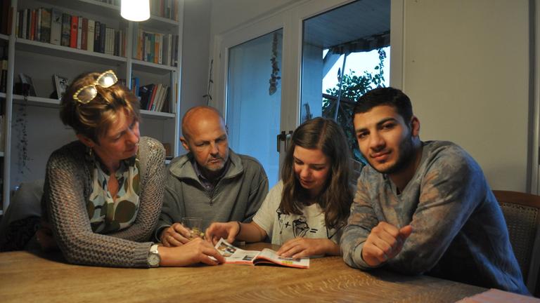"ZDFzeit: Haben wir's geschafft?": Die Gastfamilie und Mohammed sitzen an einem Tisch.