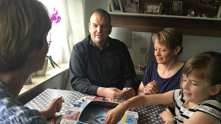 Irrsinn auf dem Wohnungsmarkt - Von Leerstand bis Luxusmieten": Autorin Renate Werner im Gespräch mit einer Familie (Mann, Frau, Kind) am Tisch sitzend.