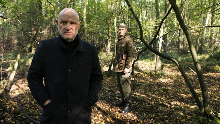 "Spreewaldkrimi - Spiel mit dem Tod": Timo Schwalm (Rick Okon) blickt im Hochwald von hinten auf den skeptisch dreinschauenden Kommissar Krüger (Christian Redl).