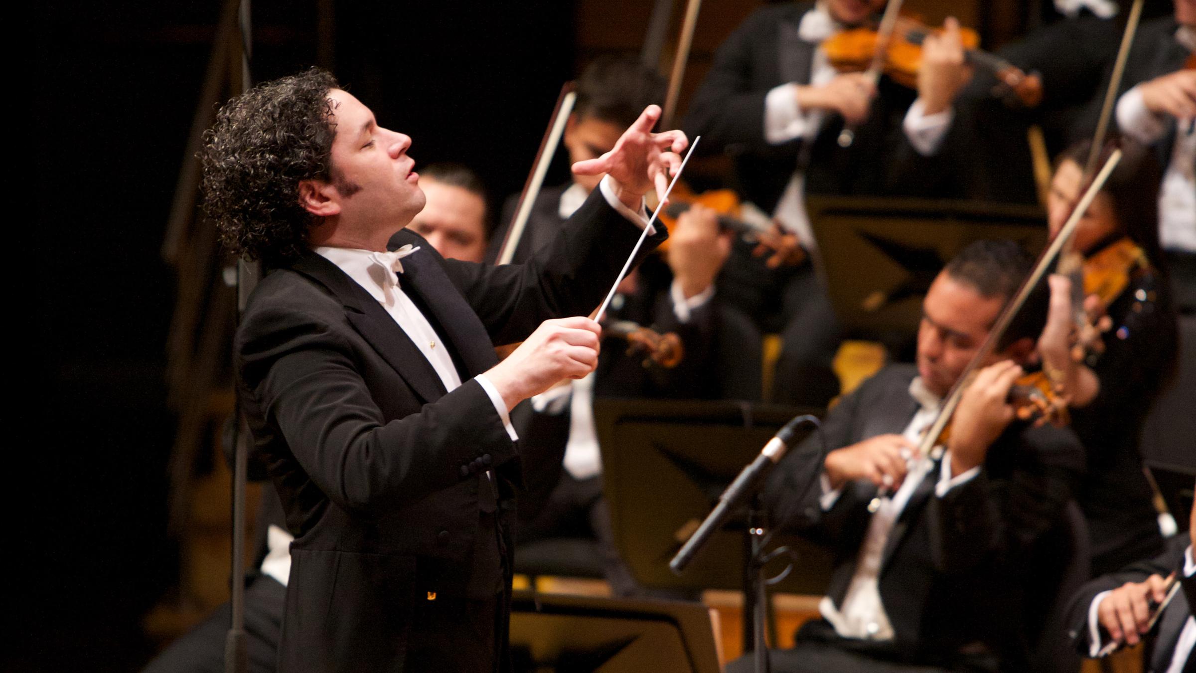 "Neujahrskonzert der Wiener Philharmoniker 2017": Gustavo Dudamel, der 2017 die musikalische Leitung des Neujahrskonzerts der Wiener Philharmoniker übernimmt,  steht dirigierend vor einem Orchester.