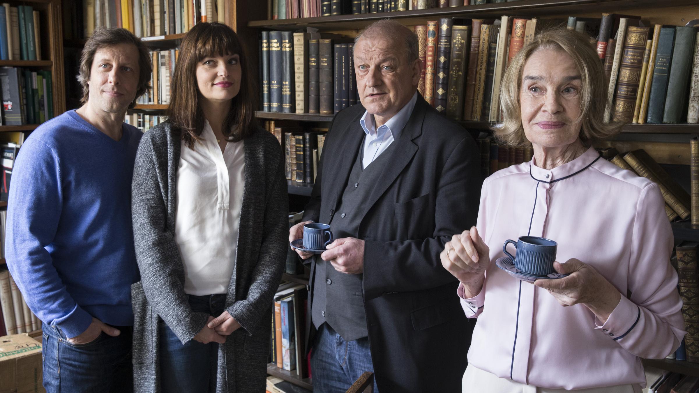 "Wilsberg - Der Betreuer": Ekki (Oliver Korittke), Alex (Ina Paule Klink), Wilsberg (Leonard Lansink) und Hanni Haffner (Gudrun Gundelach) stehen nebeneinander im Antiquariat. Wilsberg und Hanni Haffner halten Kaffeetassen in der Hand.