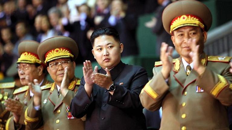 "auslandsjournal - die doku: Geheimakte Kim Jong Un - Nordkoreas rätselhafter Führer": Kim Jong Un steht zwischen mehreren Offizieren. Sie stehen klatschend in einer Reihe und blicken in die gleiche Richtung.