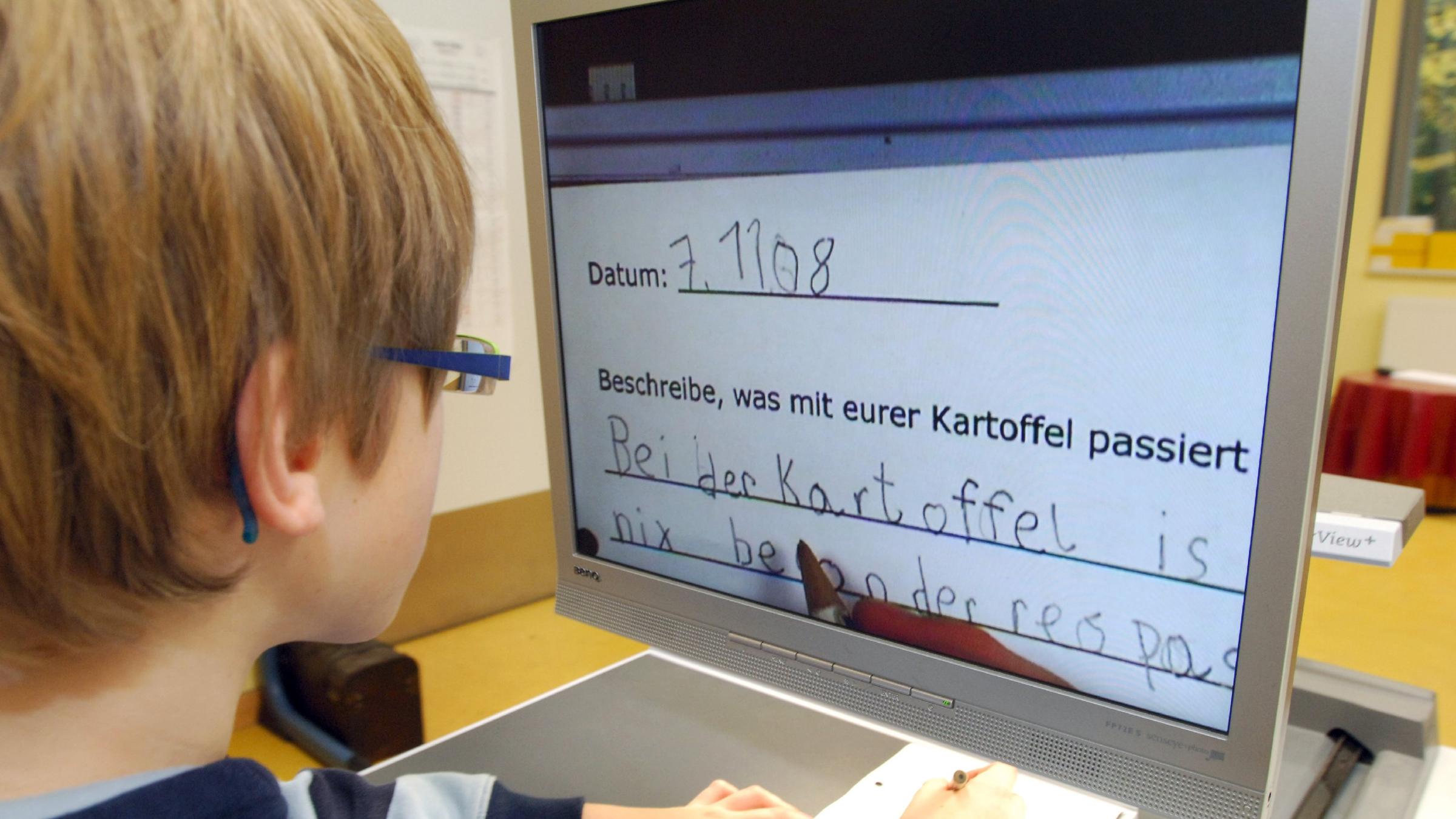 Ein sehbehinderter Junge schreibt an einem speziellen Computer