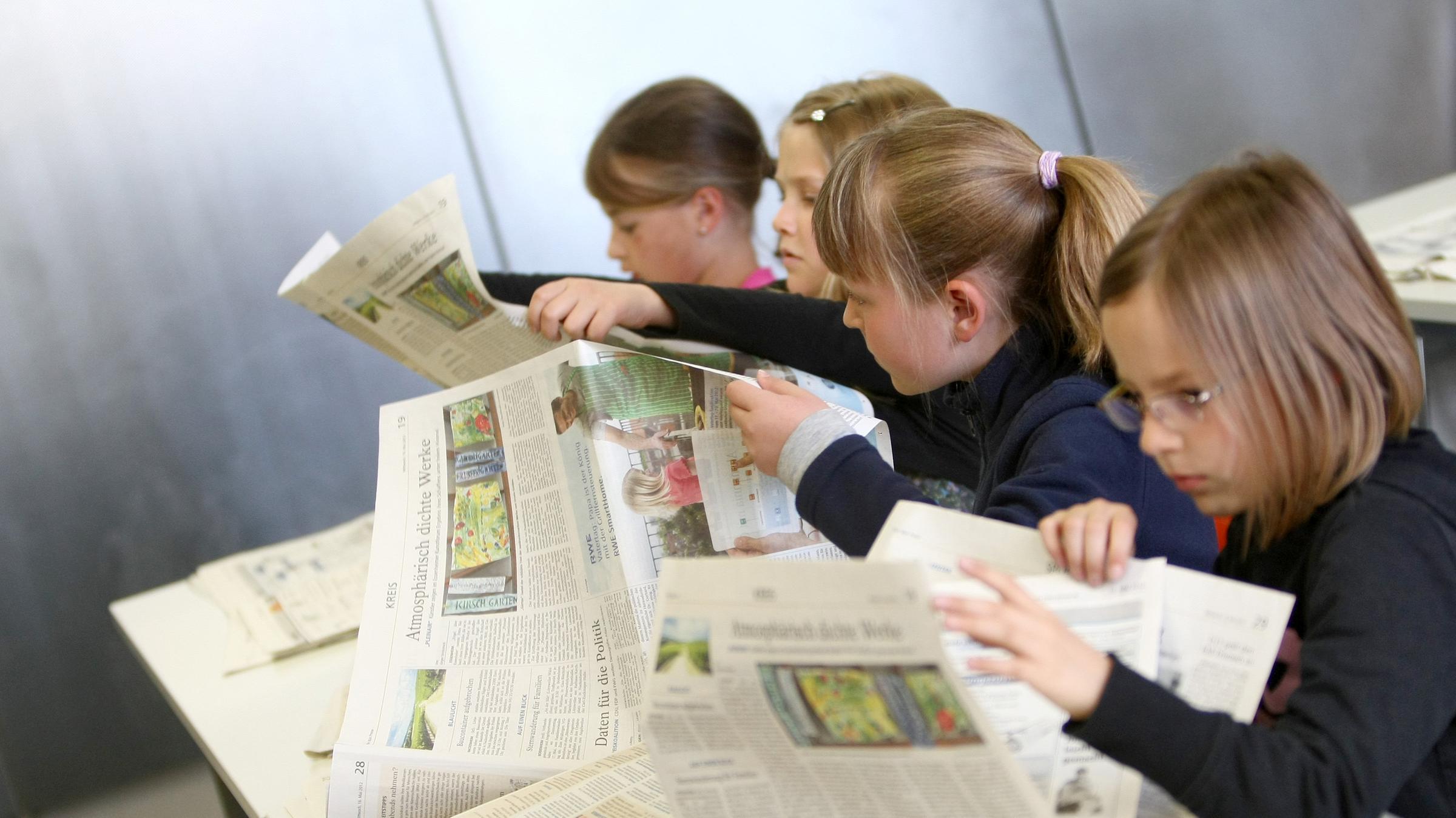 Mädchen blättern durch die Zeitung