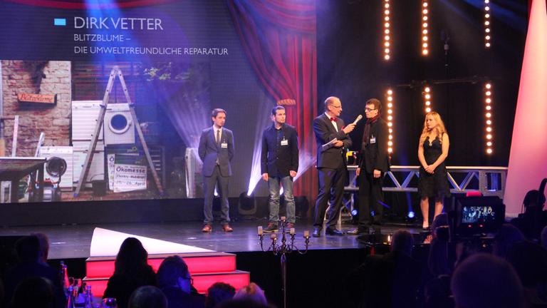 Dirk Vetter und Johannes Berger stehen auf der Bühne und nehmen den Baden Baden-Award entgegen.