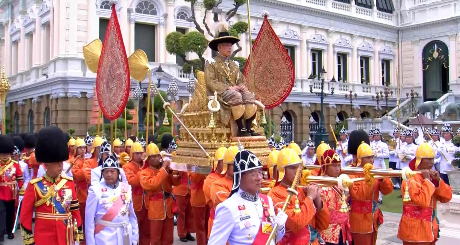 Rama X. wird auf einer königlichen Sänfte durch die Straßen von Bangkok getragen.