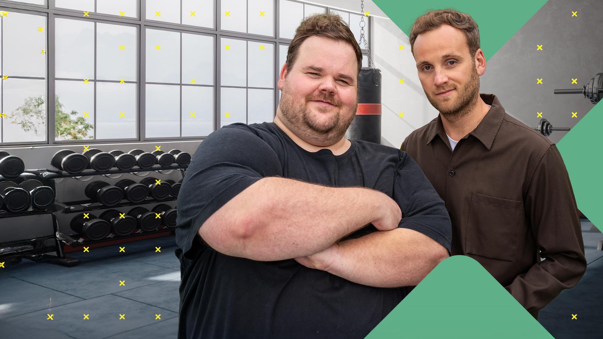 Thorsten Prix und Dr. Leon Windscheid stehen nebeneinander in einem Fitnessstudio. Thorsten Prix verschränkt die Arme und lächelt selbstbewusst, während Dr. Leon Windscheid ruhig in die Kamera blickt. Im Hintergrund sind Hantelbänke und Fitnessgeräte zu sehen.