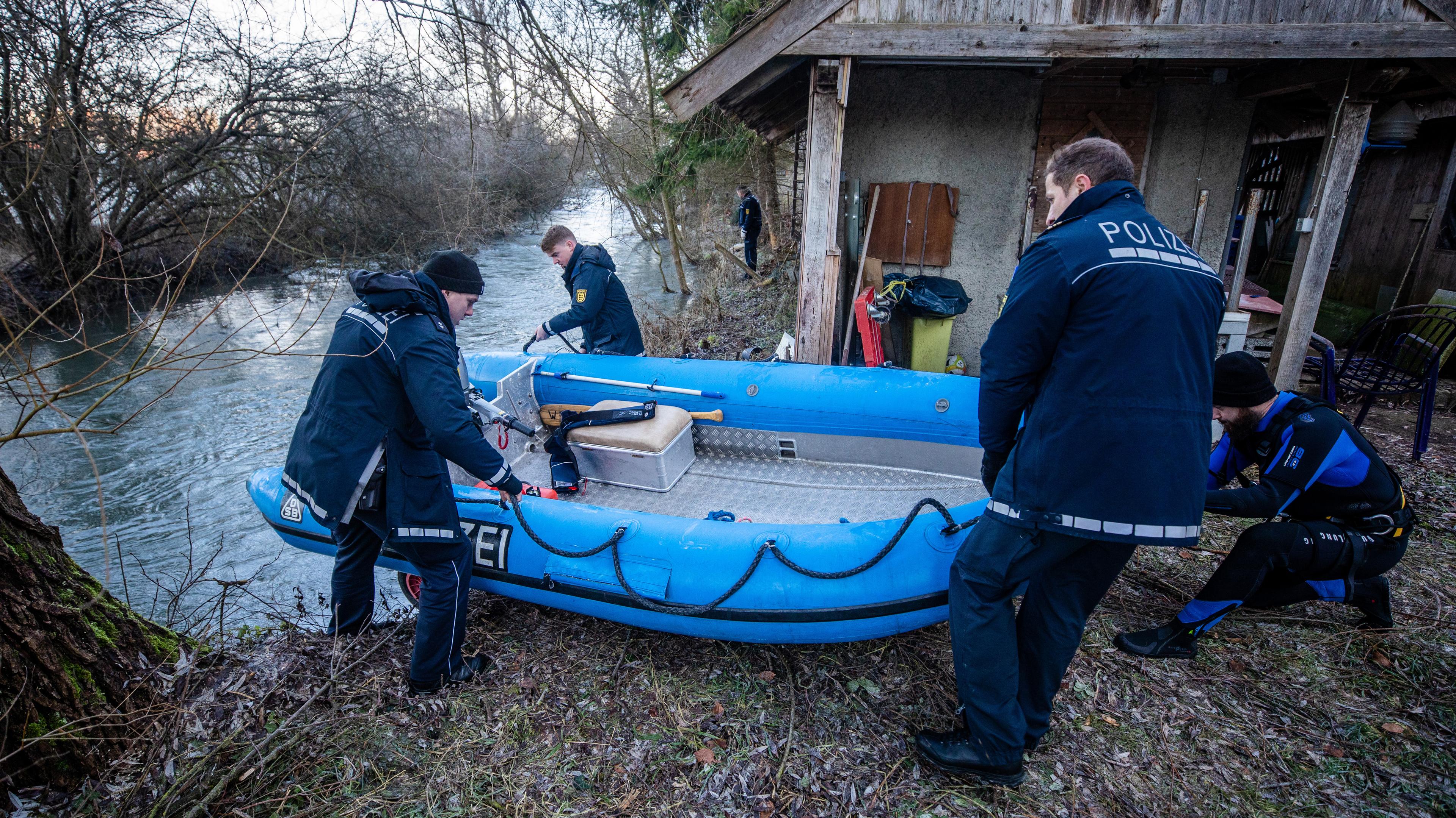 Einsatzkräfte der Polizei lassen ein Boot in das Gewässer der Lauchert ab, aufgenommen am 19.12.2023 in Bingen-Hitzkofen
