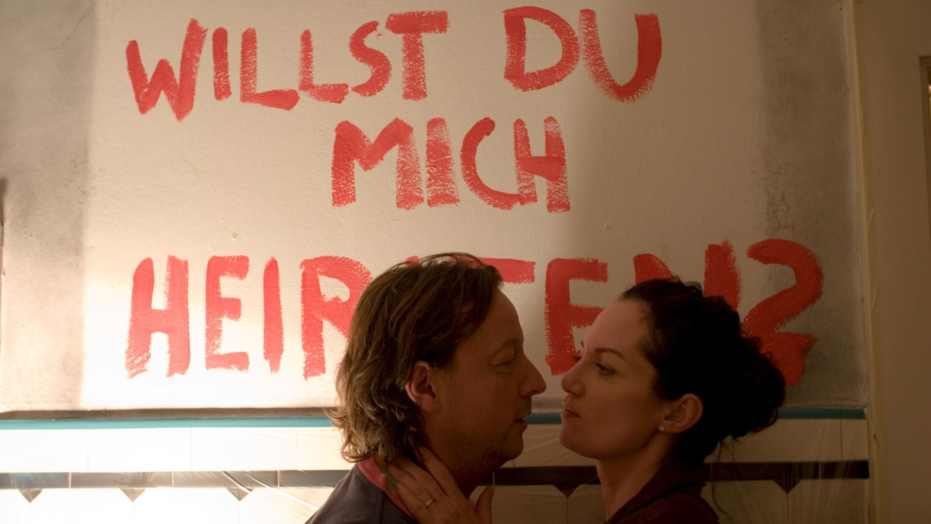 Niko Brix (Matthias Brandt) macht Kommissarin Jana Winter (Natalia Wörner), beim Renovieren der Küche einen Heiratsantrag. Im Hintergrund steht "Willst du mich heiraten" an der Wand.