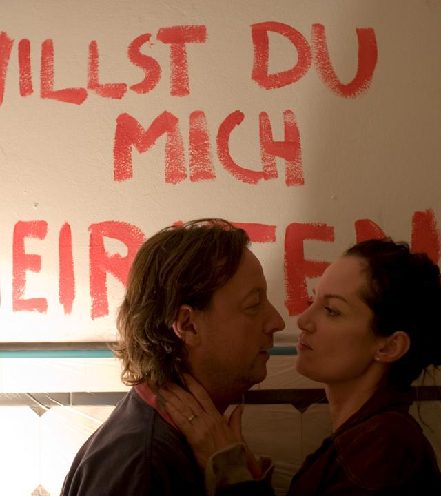 Niko Brix (Matthias Brandt) macht Kommissarin Jana Winter (Natalia Wörner), beim Renovieren der Küche einen Heiratsantrag. Im Hintergrund steht "Willst du mich heiraten" an der Wand.