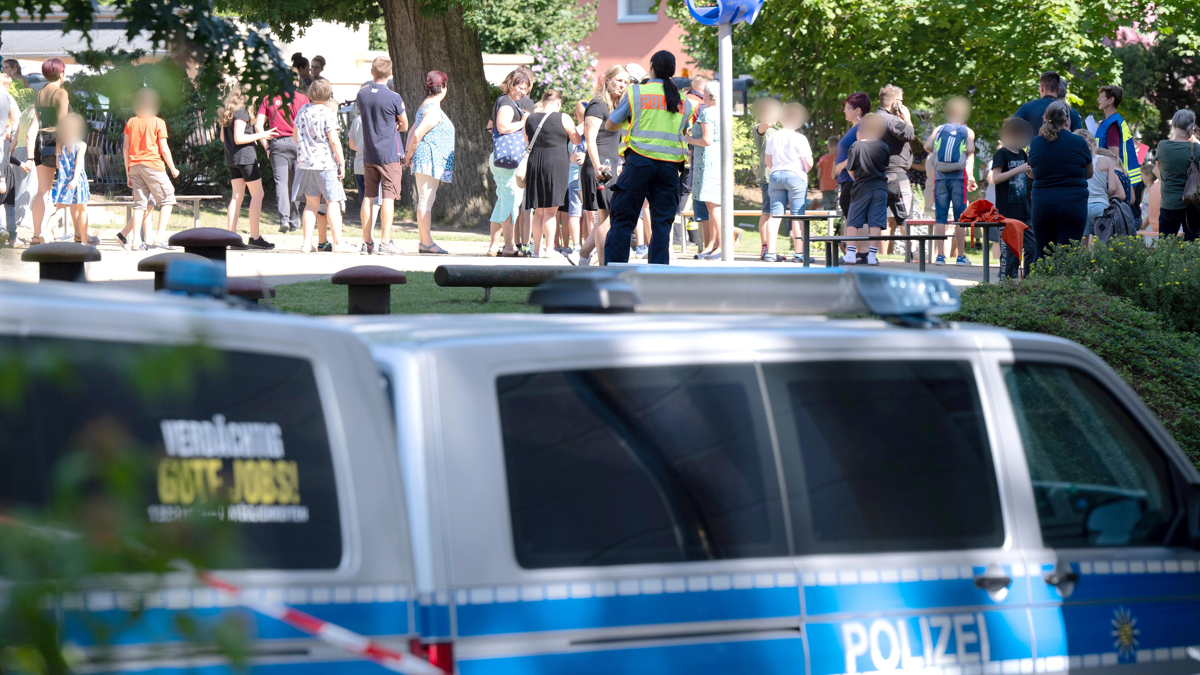 Polizisten stehen auf dem Schulhof einer Grund- und Oberschule, auzfgenommen am 23.08.2023