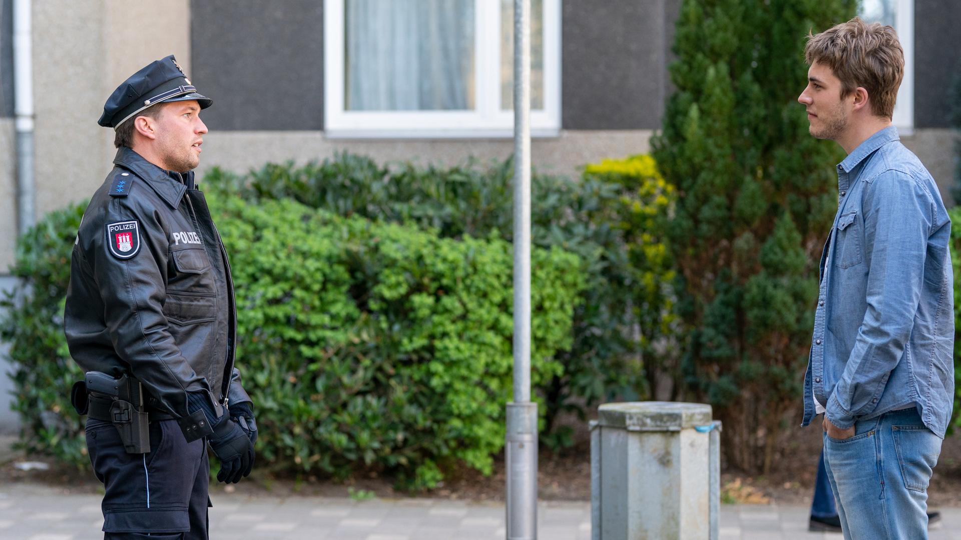 "Notruf Hafenkante - Bleib bei mir": Der Polizist Nick Brandt (Raúl Richter) und Max Lorenz (Felix Mayr) stehen sich mit etwas Abstand auf einer Straße gegenüber und sehen sich an.