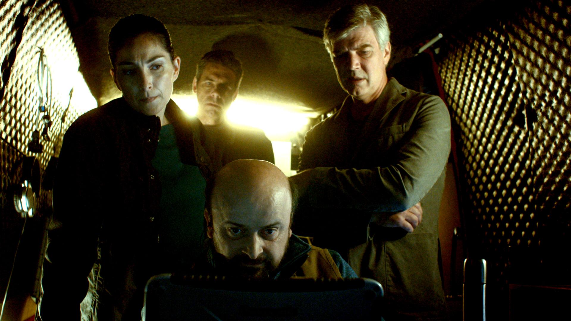 Die Ermittler der GSI, Patrick (Mikael Tornving), Matte (Zeljko Santrac), Johan (Jakob Eklund) und Sophie (Melize Karlge), stehen in einem ausgekleideten Observations-Wagen und starren auf einen Monitor.