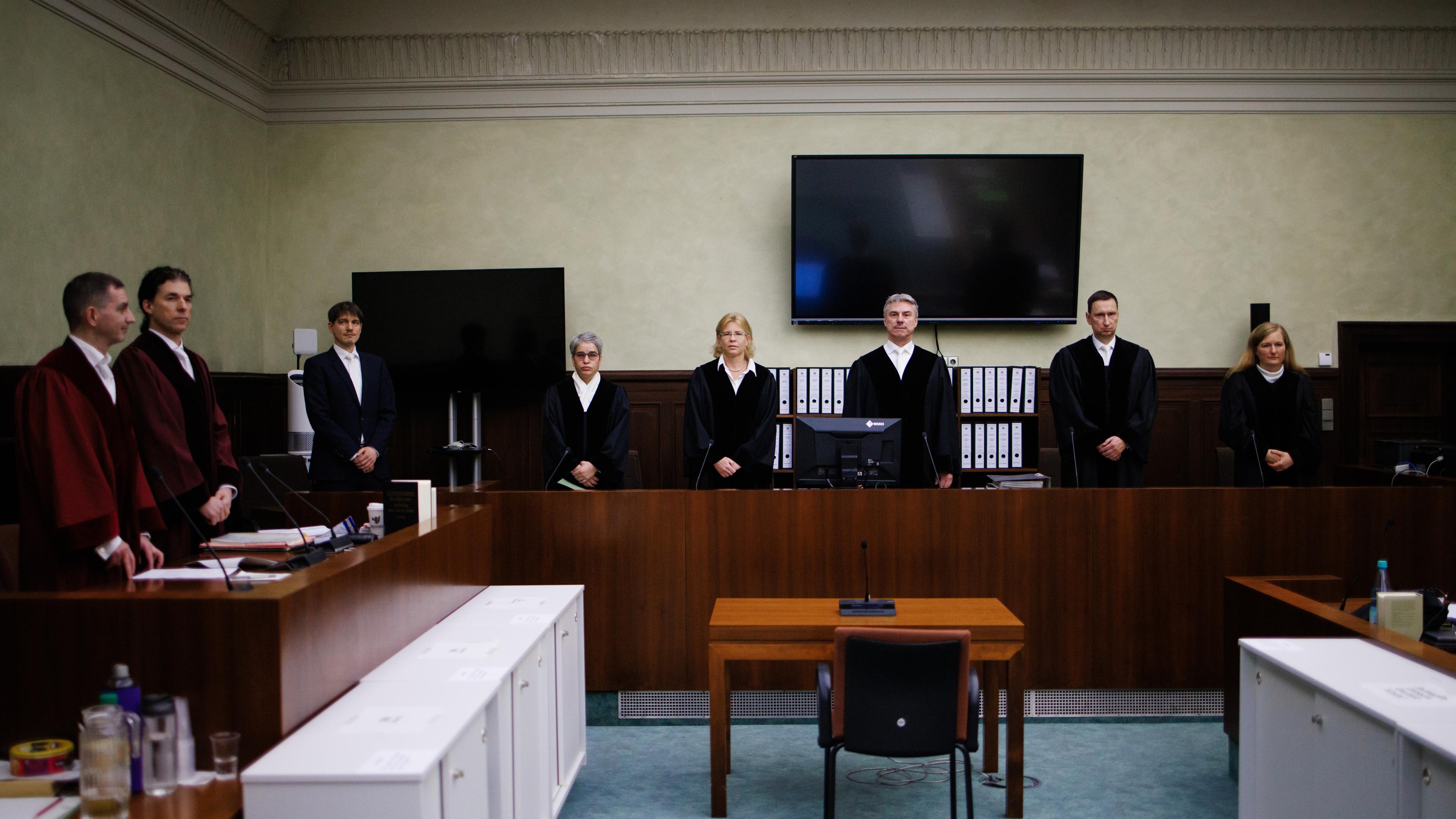he presiding judge Detlev Schmidt (3-R) and colleagues and prosecutors Lars Malskies (L) and Cai Rueffer (2-L) stand inside the court room prior to the beginning of a trial at the Kammergericht in Berlin, Germany, 13 December 2023.
