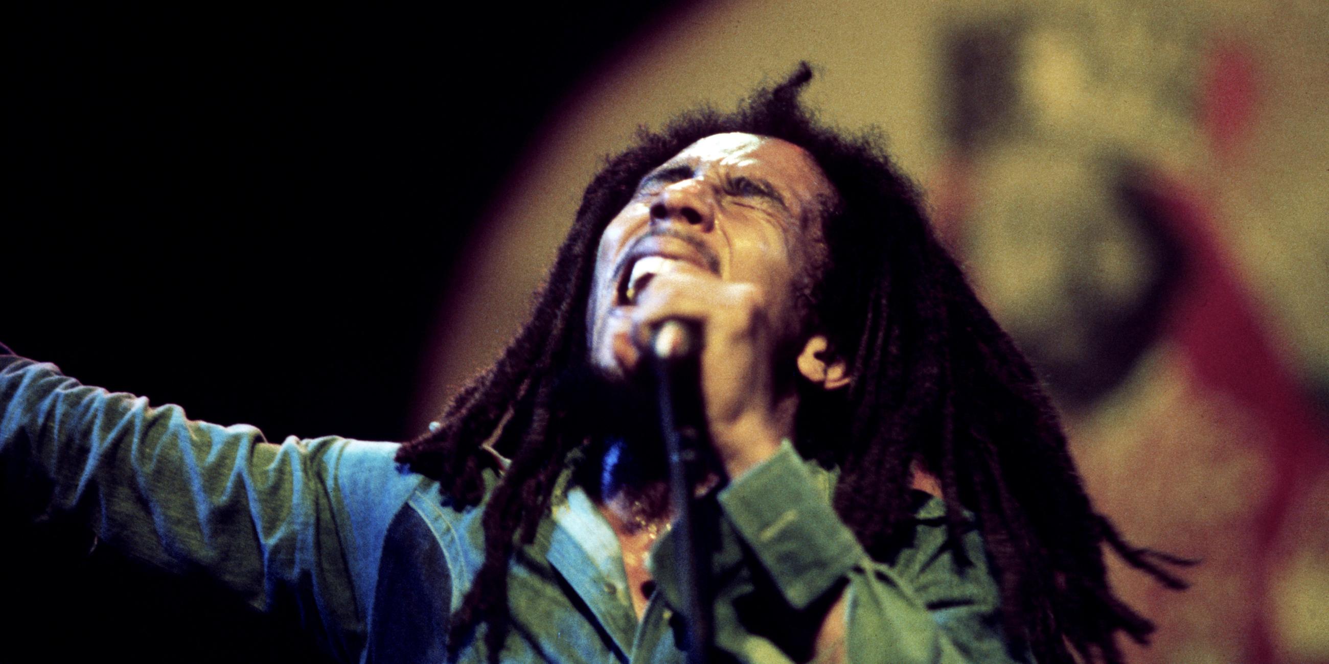 Bob Marley singt in ein Mikrofon.