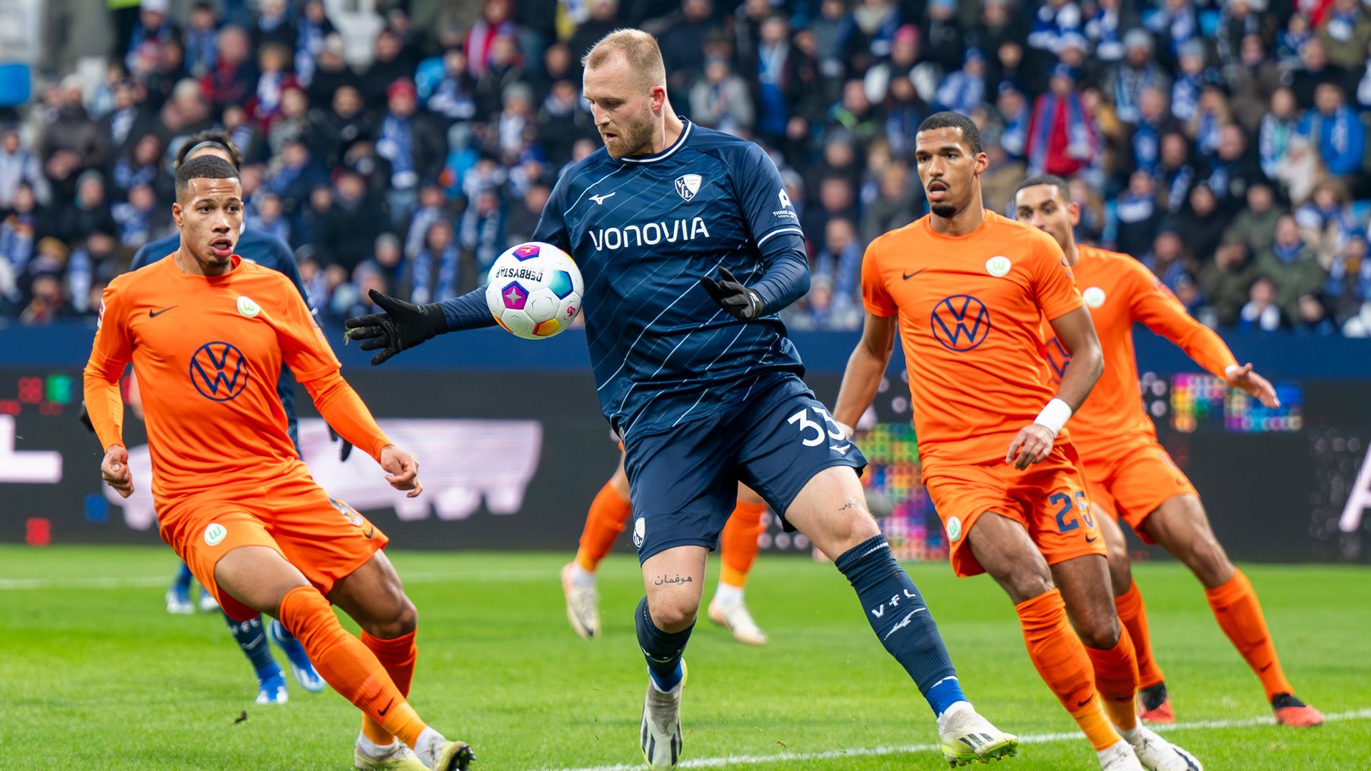 Wolfsburgs Aster Vranckx, Bochums Philipp Hofmann und Wolfsburgs Moritz Jenz kämpfen am 02.12.2023 um den Ball. 