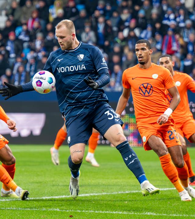 Wolfsburgs Aster Vranckx, Bochums Philipp Hofmann und Wolfsburgs Moritz Jenz kämpfen am 02.12.2023 um den Ball. 