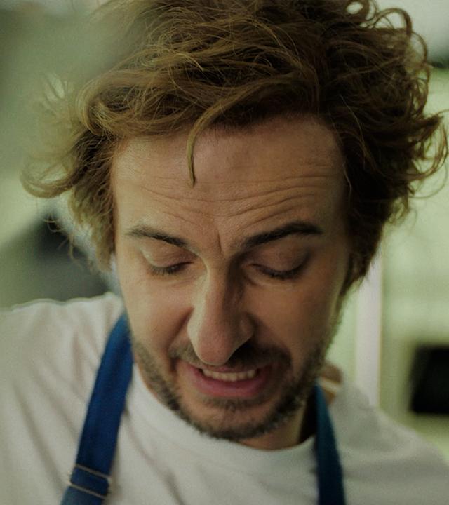 Jan Böhmermann ist in einer Kochmontur in der Nahaufnahme zu sehen. Darauf steht die Schrift "Böhmi brutzelt" ab dem 16. Juli