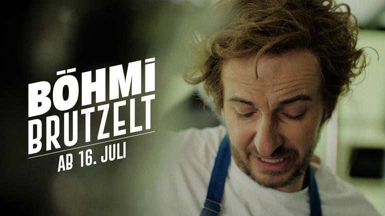 Jan Böhmermann ist in einer Kochmontur in der Nahaufnahme zu sehen. Darauf steht die Schrift "Böhmi brutzelt" ab dem 16. Juli