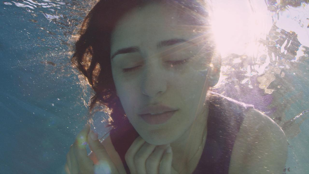 Das Gesicht einer Frau, die ins Wasser eingetaucht ist.