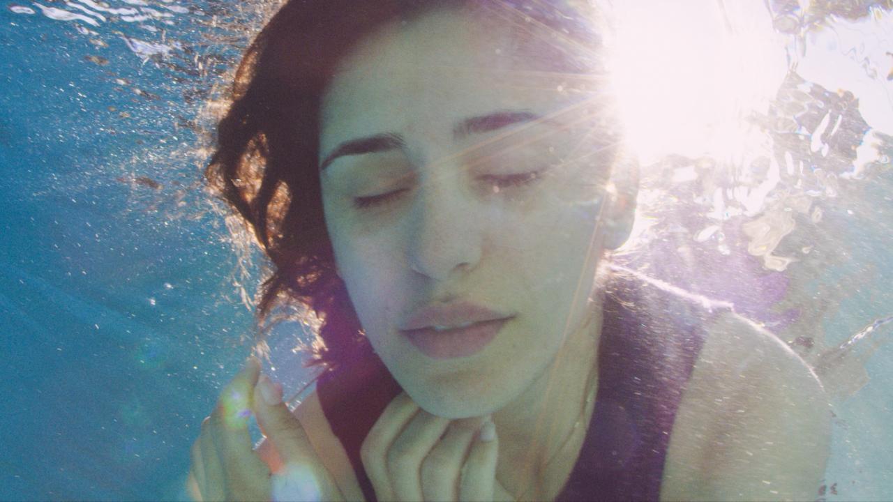 Das Gesicht einer Frau, die ins Wasser eingetaucht ist.